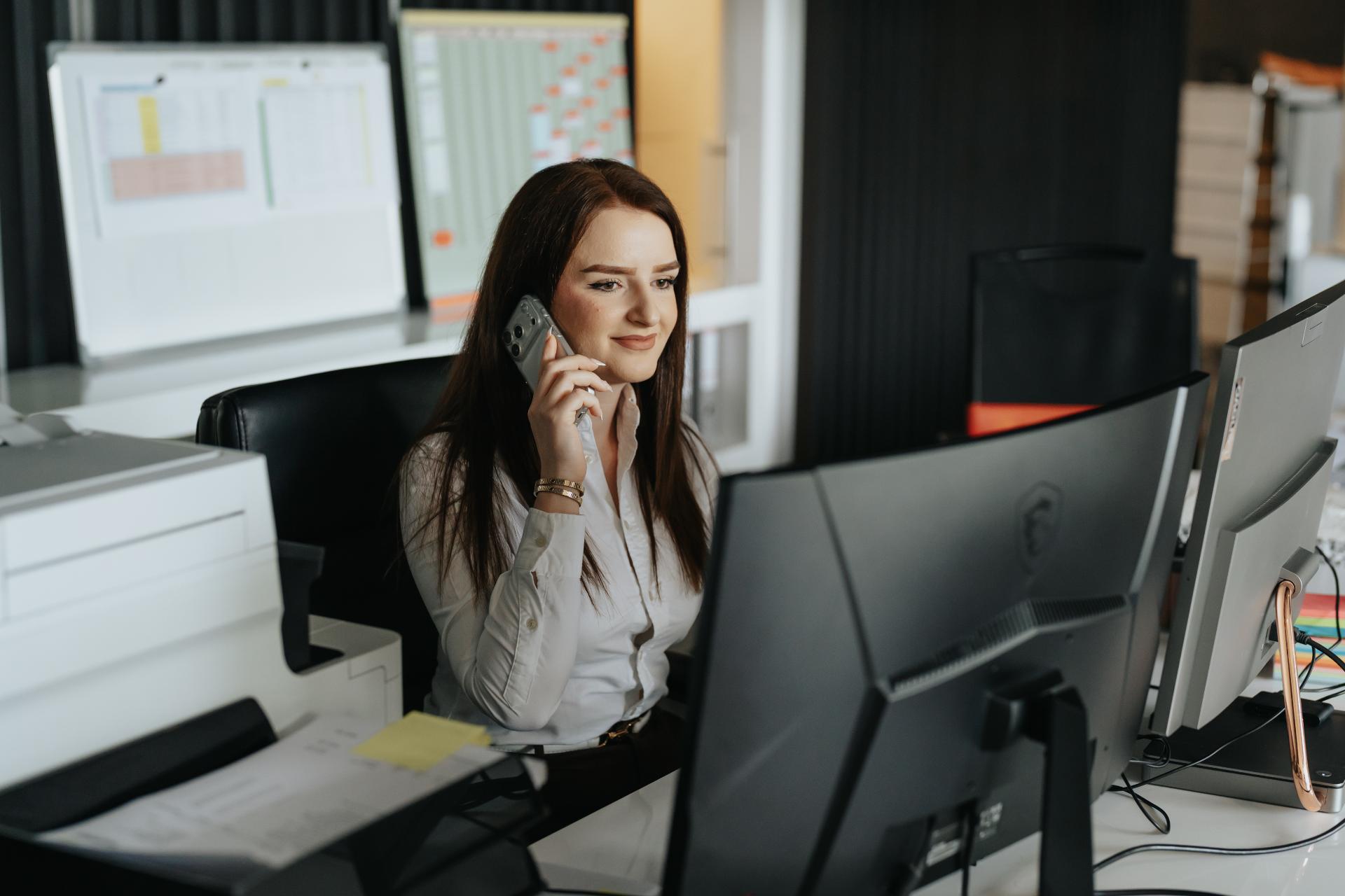 Medewerker van Artmaster aan de telefoon op kantoor