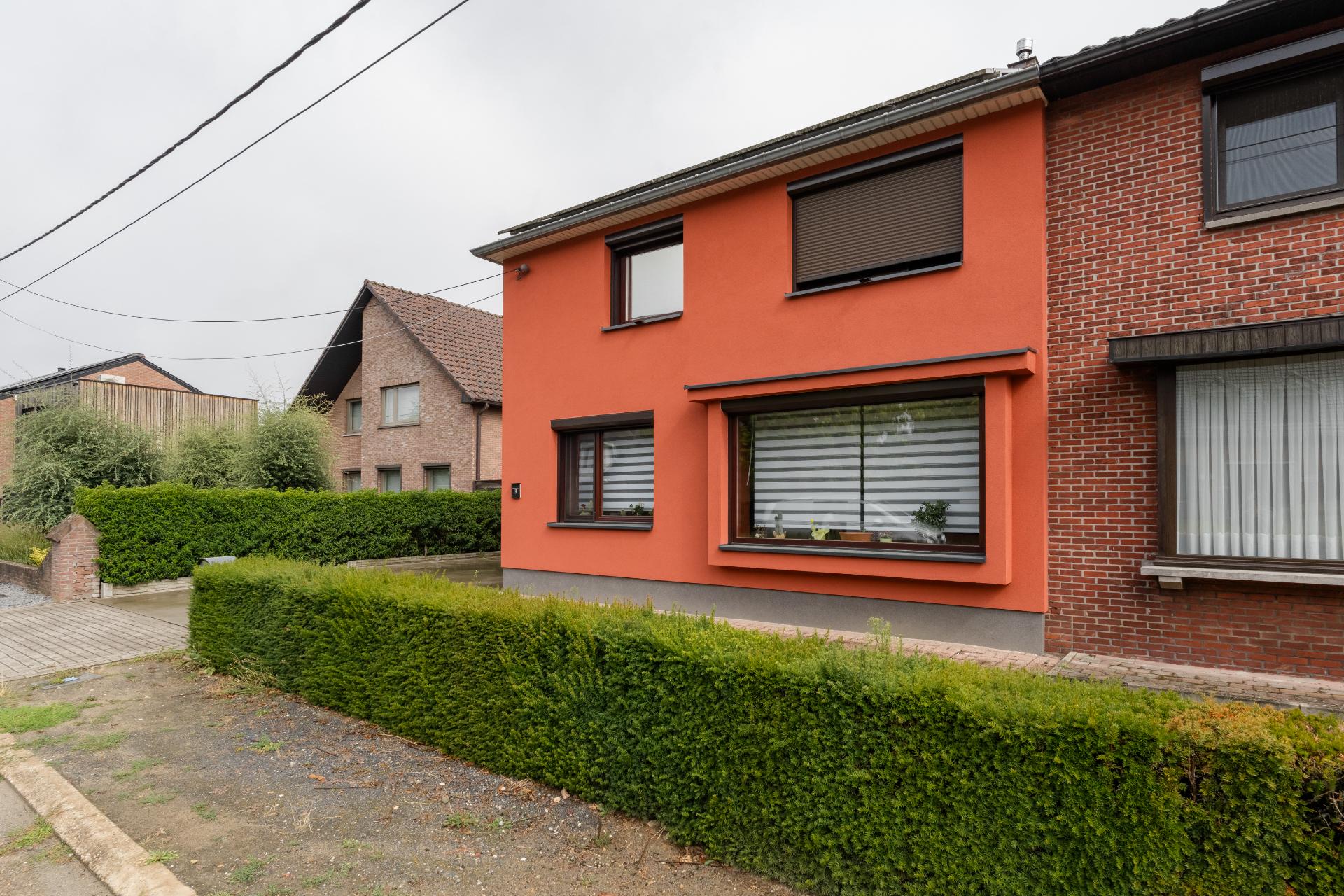 Halfopen woning met oranje gevelbepleistering