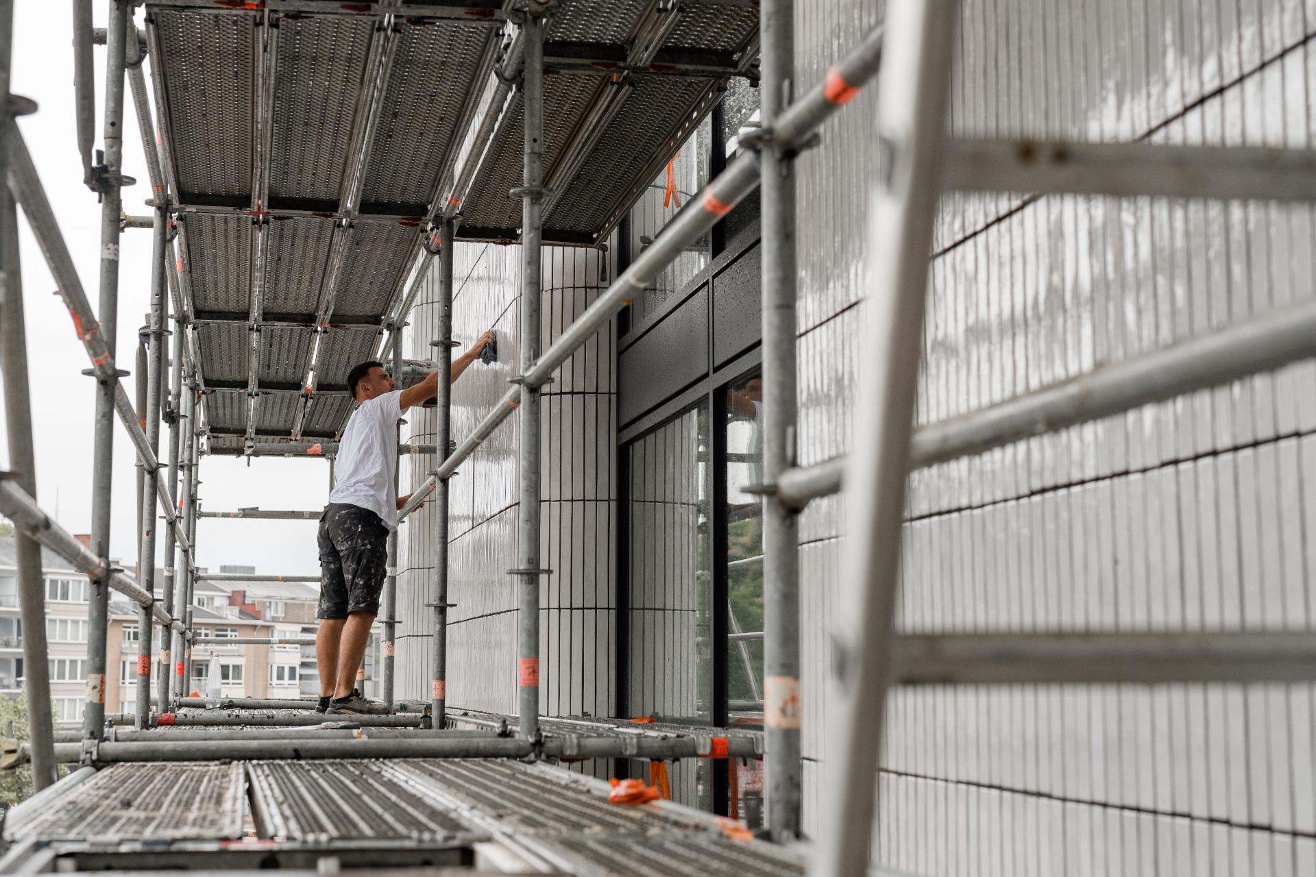 Vakman werkt aan steenstrips op de gevel
