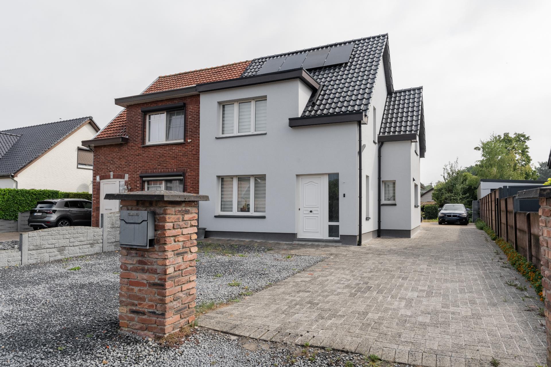 Woning en aanbouw met witte gevelbepleistering