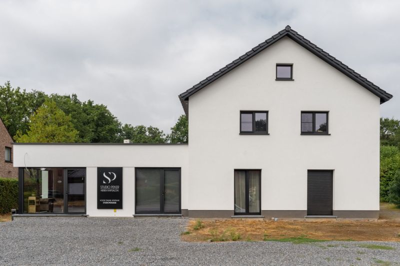 Vooraanzicht van de geïsoleerde woning en het kapsalon in Houthalen