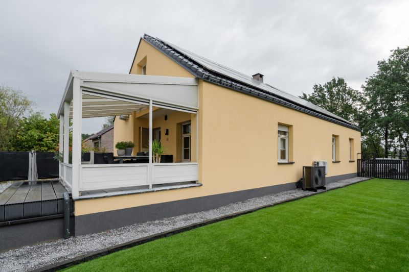 Zijgevel en tuin van de woning in Genk na gevelrenovatie